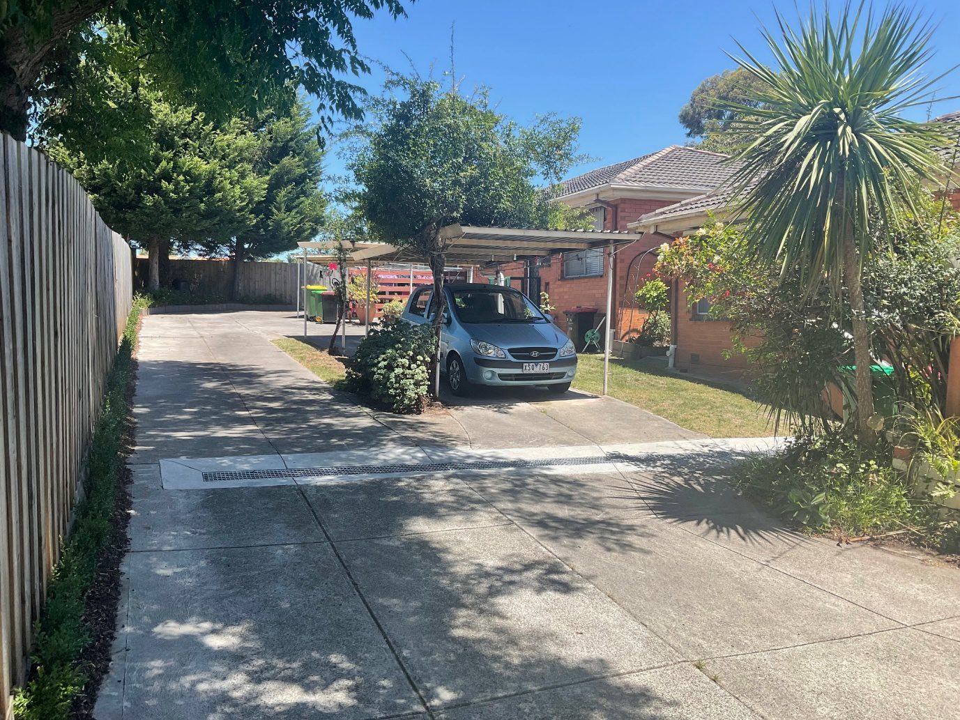 Driveway with car parked under carport
